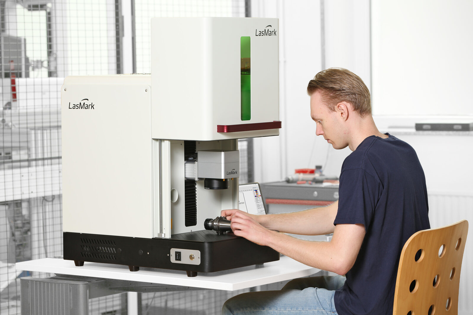 Mitarbeiter bedient den LasMark Faserlaser-Beschrifter in heller Fertigung