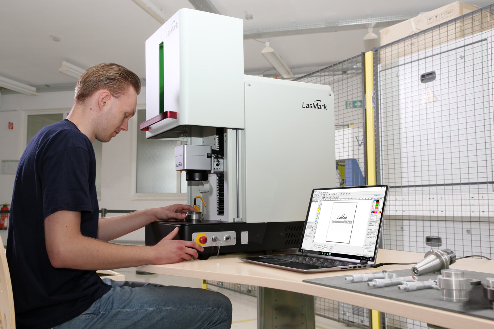LasMark Software graviert eine Seriennummer, daneben markierte Metallteile